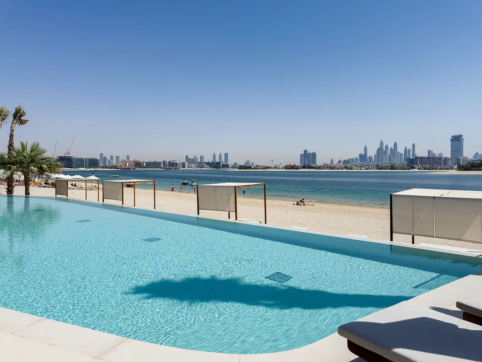 Beachfront pool with a Dubai skyline view at Ellington Beach House, Palm Jumeirah